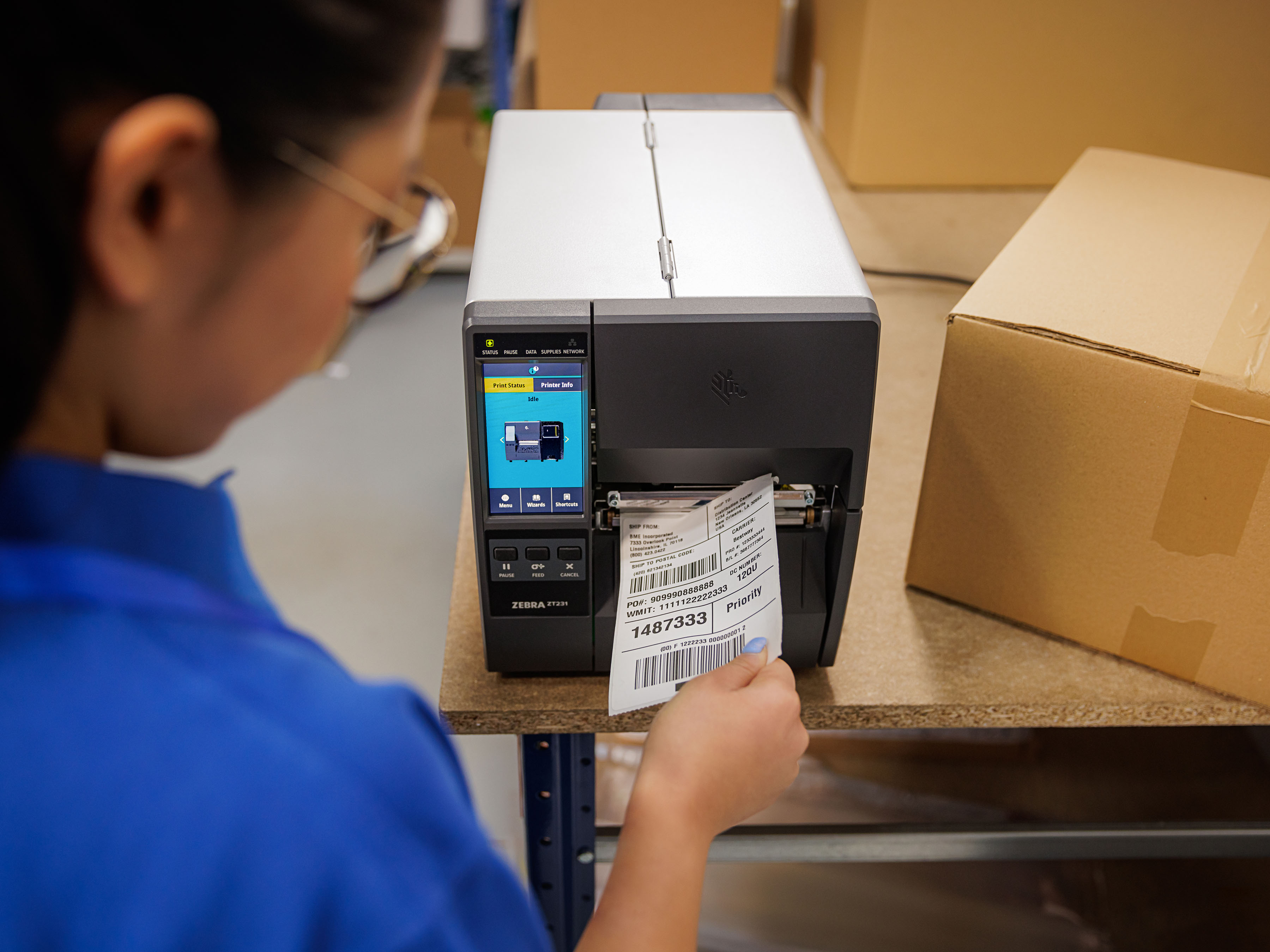 A retail store associate pulls a phenol-free label off a printer